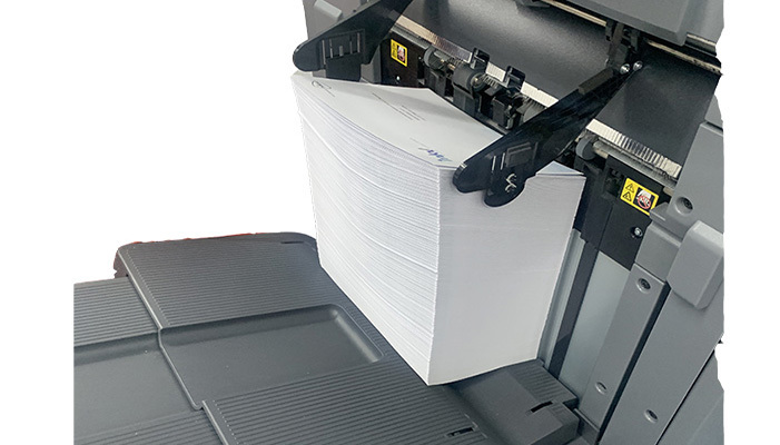 Stapel enveloppen die uit de Minolta 1070 printer komen